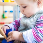 A Toddler Playing With a Blue Color Blocks