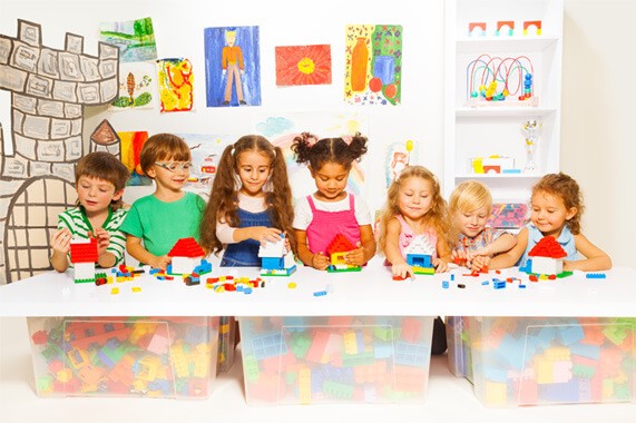 A group of children playing with legos in a playroom.