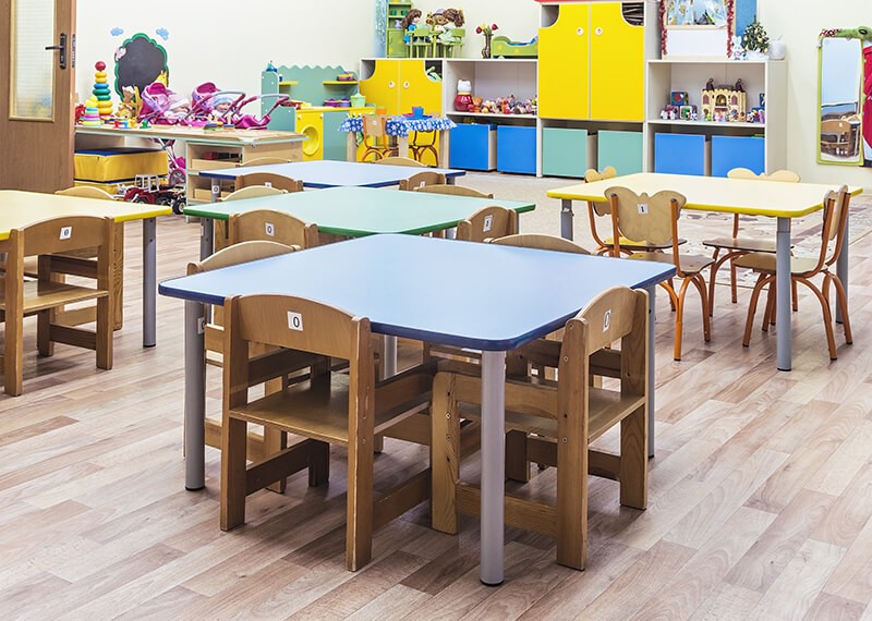 A child's playroom with tables and chairs.